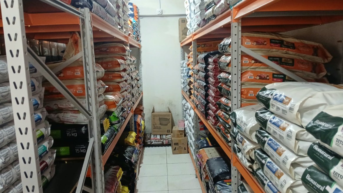 Corredor da Agropet Inambu entre estantes cheias de sacos de ração